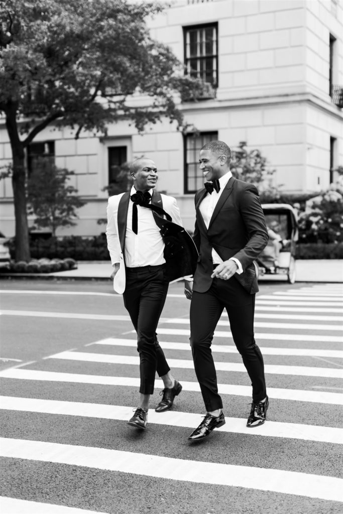 gay wedding portrait of two men running across the street at central park