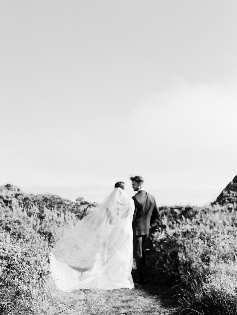 Bride and groom  walking at wedding ceremony on bluff at the Sea Ranch Lodge