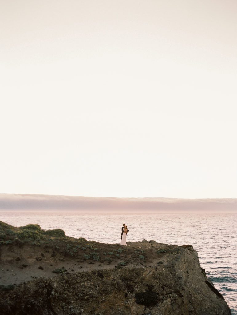 bride and groom in the distance on the bluff at The Sea Ranch lodge