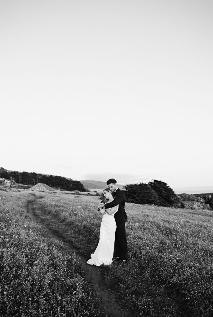 bride and groom hug on the bluff at sea ranch lodge